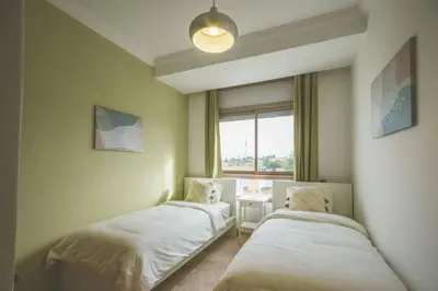 two beds in a room with a window at lovely 2 bedroom vacation home with pool/beach in Skhirat
