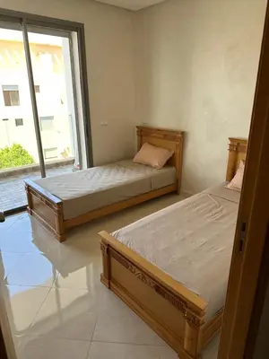 two beds in a room with a window at Les perles de mimosa Mohammédia in Mohammedia