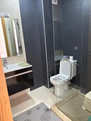a bathroom with a toilet and a sink and a mirror at Les perles de mimosa Mohammédia in Mohammedia