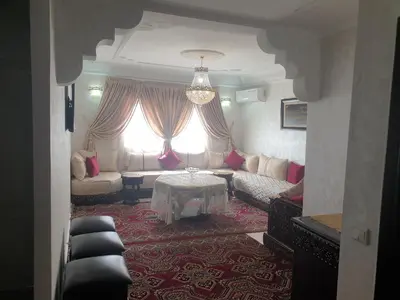 a living room with a couch and a table at Appartement Meublé AIN SEBAA in Aïn Sebaa
