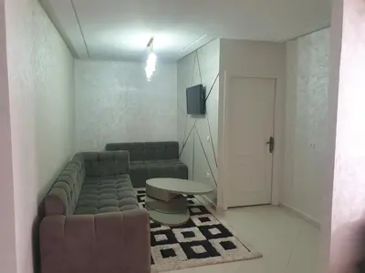 a living room with a couch and a table at Appartement Meublé AIN SEBAA in Aïn Sebaa