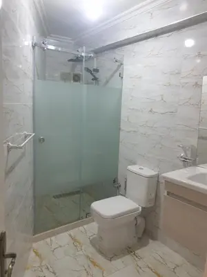 a bathroom with a shower and a toilet and a sink at Appartement Meublé AIN SEBAA in Aïn Sebaa