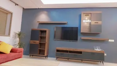 a living room with a tv on a blue wall at Appartement Nova - Costa Bouznika in Bouznika