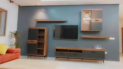 a living room with a tv on a blue wall at Appartement Nova - Costa Bouznika in Bouznika