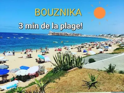 a beach with a large group of people on it at Appartement Nova - Costa Bouznika in Bouznika