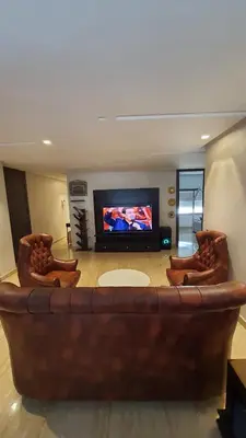 a large brown couch in a living room with a tv at Casa Fainna in Casablanca