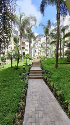 a path in a park with palm trees and a building at Casa Fainna in Casablanca