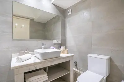 a bathroom with a sink and a toilet and a mirror at Grand Appartement Vue mer à Ain Diab - Calme Absolu in Casablanca
