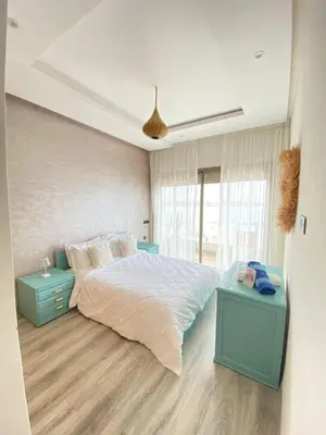 a bedroom with a large bed with two night stands at Appartement en bord de mer in Pont Blondin