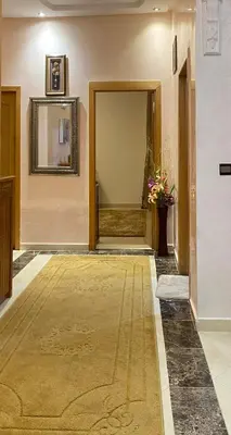 a hallway with a rug on the floor and a mirror at Luxurious Holiday Home in Temara
