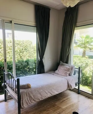 a bed in a bedroom with a large window at Hébergement bord de mer in Casablanca