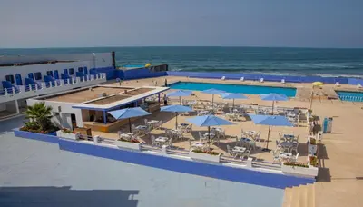 an overhead view of a pool with umbrellas and the ocean at Hotel Tropicana in Casablanca