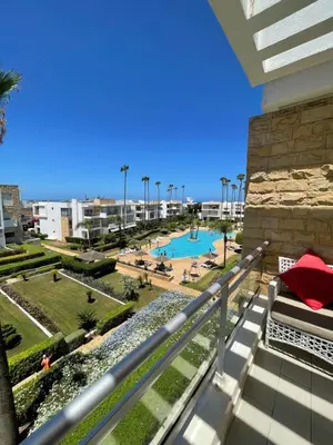 a view from the balcony of a resort with a pool at Eden tamaris résidence in Dar Bouazza