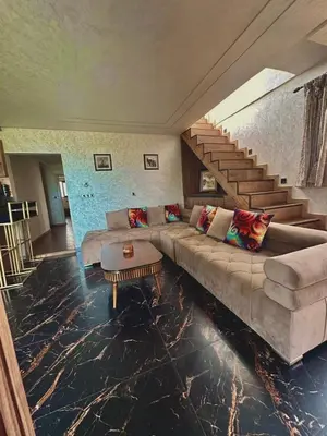 a living room with a couch and a staircase at sea view appart and roof top, jack beach Tamaris, Dar Bouaza in Casablanca