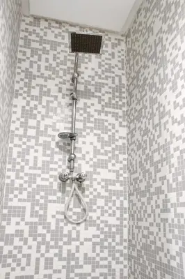 a shower in a bathroom with gray and white tiles at Luxury 3 Bedroom Apartment in the Heart of Agdal by MasterHost in Rabat