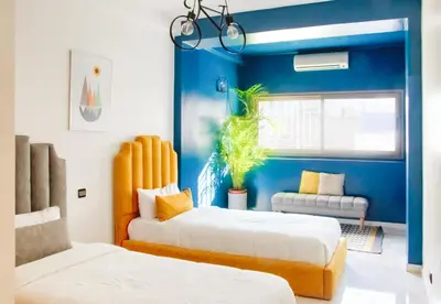 two beds in a room with blue walls at Luxury 3 Bedroom Apartment in the Heart of Agdal by MasterHost in Rabat