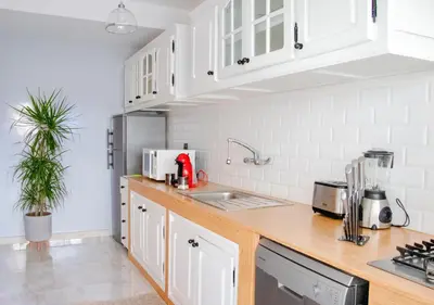 a kitchen with white cabinets and a red appliance at Luxury 3 Bedroom Apartment in the Heart of Agdal by MasterHost in Rabat