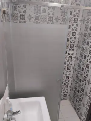 a bathroom with a shower with a sink and a toilet at Appartement Cozy Louizia in Ben Yakhlef