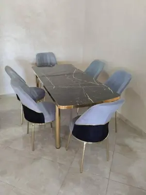 a wooden table with four chairs around it at Appartement Cozy Louizia in Ben Yakhlef