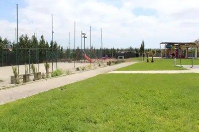 a park with a basketball hoop and a playground at Ferme d'hôte Evasio in Sidi Rahal