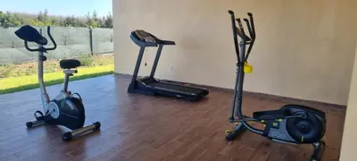 three exercise bikes sitting on a wooden floor at Ferme d'hôte Evasio in Sidi Rahal