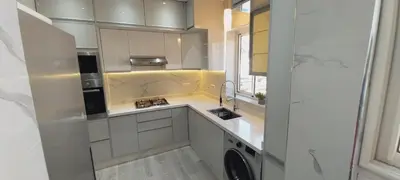 a kitchen with white cabinets and a washer at Residence Al Kawtar in Mohammedia