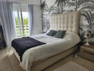 a bedroom with a large bed with a large window at Appartement Luxueux vue Mer dans Résidence avec piscines et jardin in Dar Bouazza