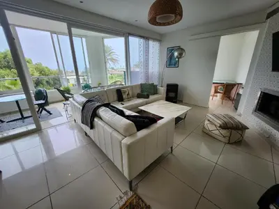a living room with a couch and a table at Appartement Luxueux vue Mer dans Résidence avec piscines et jardin in Dar Bouazza