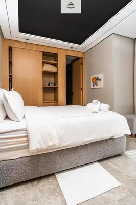 a bedroom with a large bed with a tv on the wall at The Besty Ocean Suite-By Ayla Stay in Casablanca