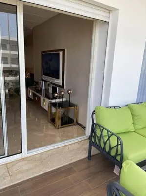 a living room with a couch and a television at Appartement de luxe à peninsula in Casablanca