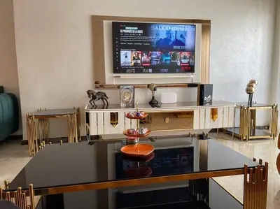 a living room with a large screen tv and a table at Appartement de luxe à peninsula in Casablanca