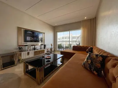 a living room with a couch and a tv at Appartement de luxe à peninsula in Casablanca