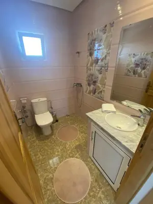 a bathroom with a toilet and a sink and a mirror at Villa in Rabat in Oulad Mbark