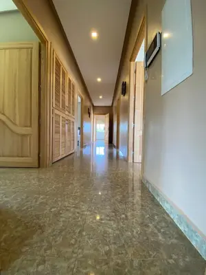 an empty hallway with wooden doors and marble floors at Villa in Rabat in Oulad Mbark