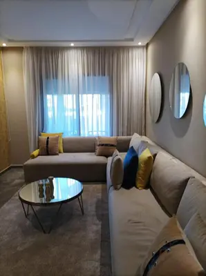 a living room with a couch and a table at Amwaj Beach Sidi Rahal in Casablanca