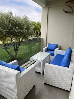 a patio with wicker chairs and a table at Amwaj Beach Sidi Rahal in Casablanca