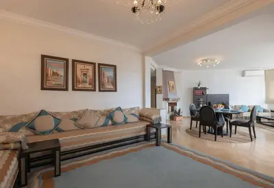 a living room with a couch and a table at Cosy Apartment 200 M2 Hay Ryad Rabat in Rabat