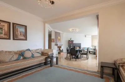 a living room with a couch and a table at Cosy Apartment 200 M2 Hay Ryad Rabat in Rabat