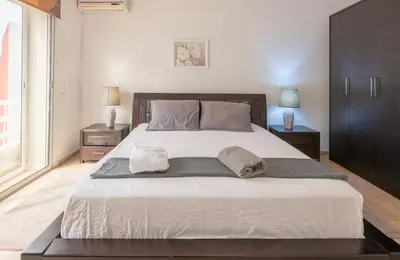 a bedroom with a large bed with two pillows on it at Cosy Apartment 200 M2 Hay Ryad Rabat in Rabat