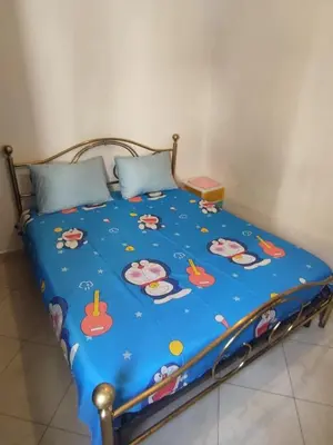 a bed with a blue comforter with hello kitty on it at Molto carino ben solare in Sidi Rahal