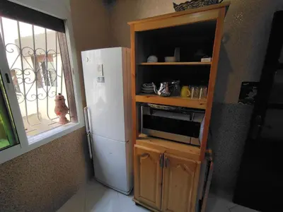 a kitchen with a white refrigerator and a window at Molto carino ben solare in Sidi Rahal