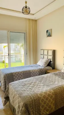 two beds in a bedroom with a large window at Residence Casa Bay Sidi Rahal in Sidi Rahal