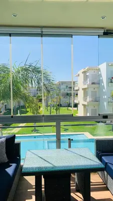 a patio with a table and a view of a pool at Residence Casa Bay Sidi Rahal in Sidi Rahal