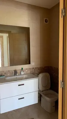 a bathroom with a sink and a toilet and a mirror at Residence Casa Bay Sidi Rahal in Sidi Rahal