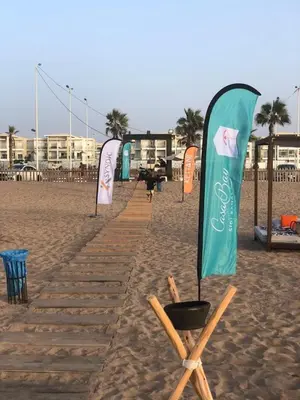 a row of signs on a sandy beach at Residence Casa Bay Sidi Rahal in Sidi Rahal