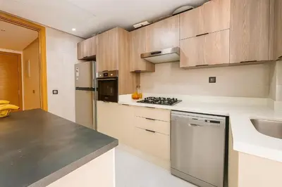 a kitchen with wooden cabinets and stainless steel appliances at Lux, comfy and cosy Apartment in Casablanca