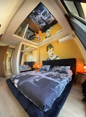 a bedroom with a bed with a tv on the wall at La terrasse d'Audrey - Short stay au coeur du Maarif in Casablanca