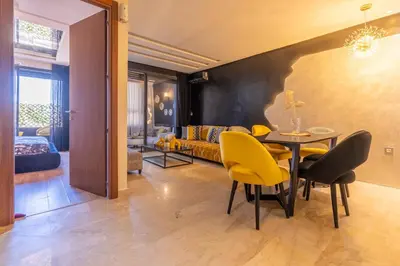 a living room with a dining table and yellow chairs at La terrasse d'Audrey - Short stay au coeur du Maarif in Casablanca