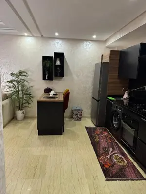 a room with a kitchen with a stove and a table at App à côté du parc et corniche in Mohammedia