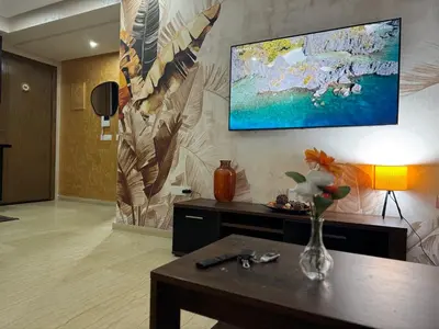 a living room with a table and a painting on the wall at App à côté du parc et corniche in Mohammedia
